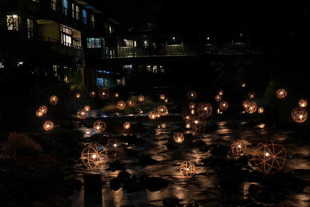 many bamboo lanterns hovering over a bridge during Kurokawa Onsen nightime winter illumination event