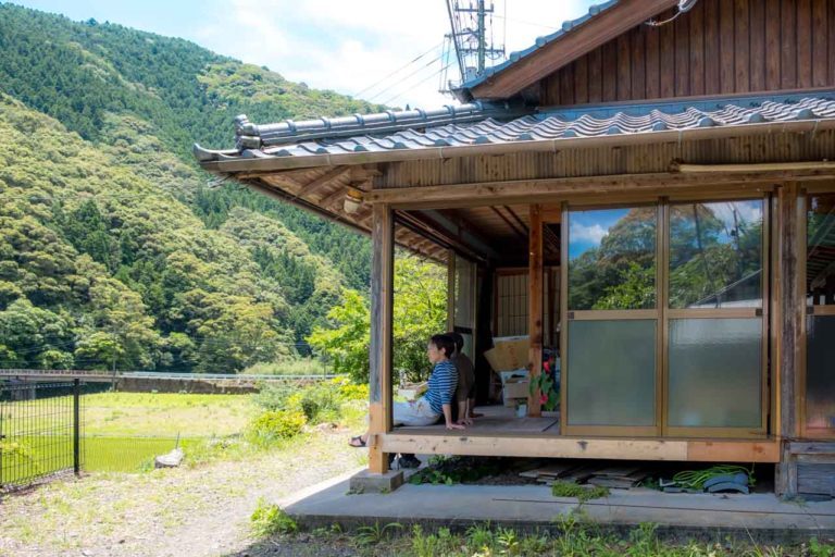 two people sitting on outer deck of traditional japanese house in japan