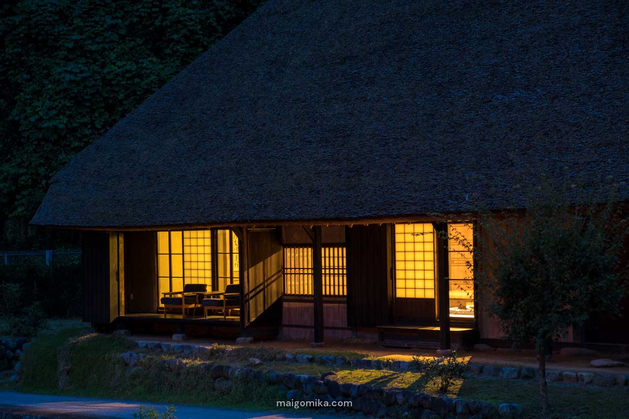 traditional japanese folk house at night with gold lights