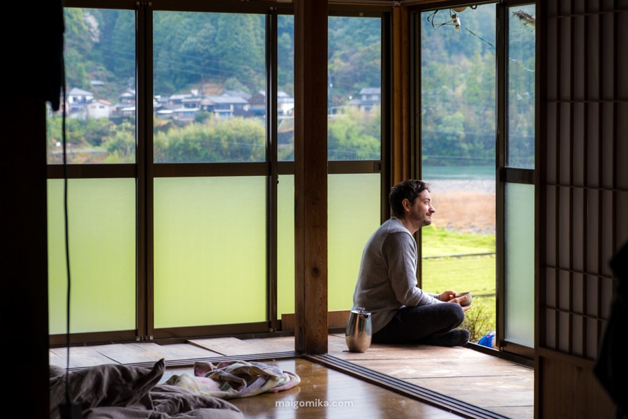 man sitting in engawa in a traditional Japanese house, looking outside