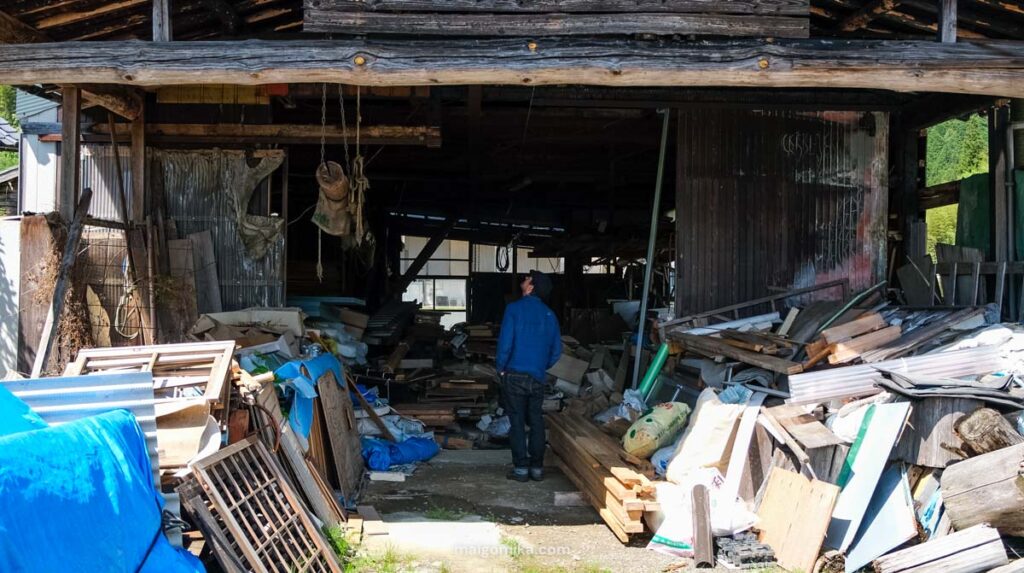 an abandoned workshop with man standing and looking up at the ceiling