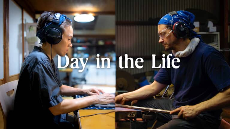 man and woman facing each other working, woman working on computer, man at blacksmith stone grinding knife