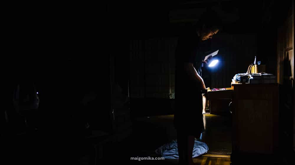 woman with flashlight looking in a drawer during a power outage in Japan