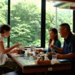 three people sitting at table eating a meal together