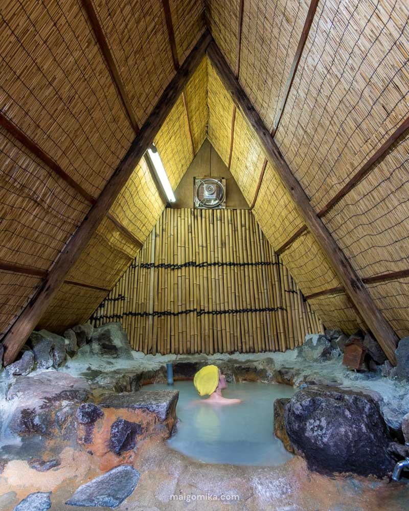 woman in a traditional thatched building in Japan, sitting in an onsen hot spring in Myoban Onsen, Beppu, Japan